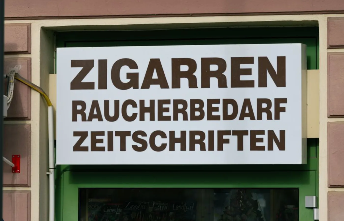 Firmă luminoasă montată la intrarea unui magazin